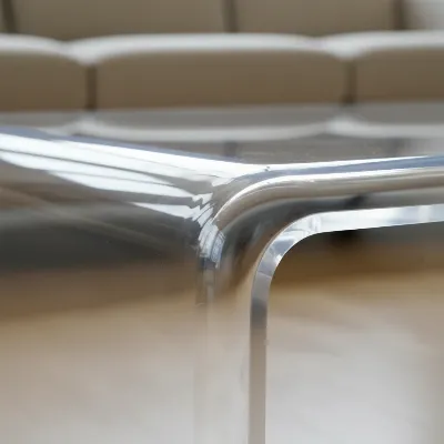 Close-up of the seamless curved edge of a CB2 Peekaboo Clear Acrylic Coffee Table.