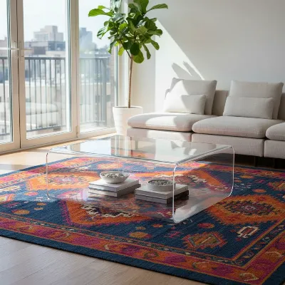 A CB2 Peekaboo Clear Acrylic Coffee Table in a modern, light-filled living room with a colorful rug.