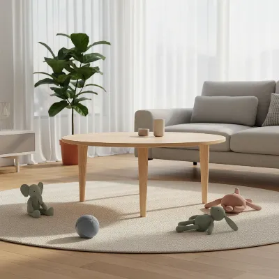 A round, light wood coffee table in a bright, modern living room with children's toys scattered nearby.